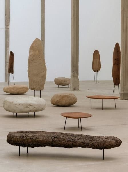 Stone-like furniture pieces in a bright gallery.