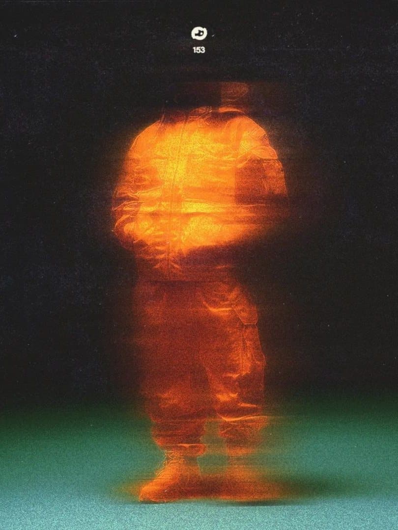 A blurred orange figure against a dark ground with a green floor.
